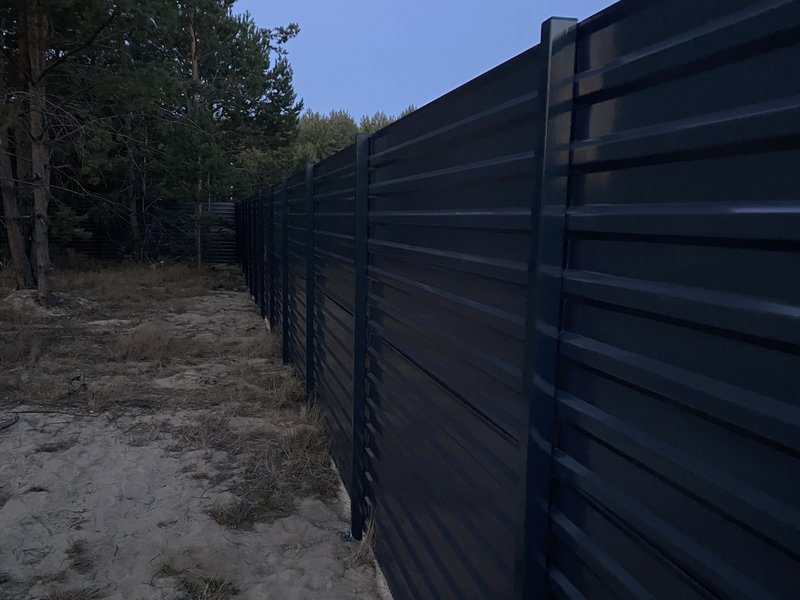 Забор жалюзи вдоль леса